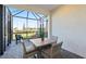 Screened lanai with a table and four chairs overlooking a grassy backyard area with young trees at 14313 Eagle Branch Dr, Nokomis, FL 34275
