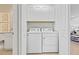 Laundry room featuring a side-by-side washer and dryer and white cabinets above the machines at 14313 Eagle Branch Dr, Nokomis, FL 34275