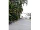 Exterior image displaying a wooden dock leading to the water, surrounded by lush tropical foliage and palm trees at 14555 N Bayshore Dr, Madeira Beach, FL 33708