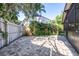 A backyard featuring a brick-paved patio area and manicured greenery along the fence at 16107 Dawnview Dr, Tampa, FL 33624