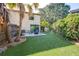 Charming backyard featuring a patio, artificial grass and lush landscaping with tropical palm trees at 16107 Dawnview Dr, Tampa, FL 33624