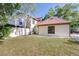 Exterior showcasing a front lawn, blue front door, and a white fence, surrounded by trees at 16107 Dawnview Dr, Tampa, FL 33624