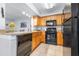 Kitchen area featuring wood cabinets, a black oven, and stainless steel faucet at 16107 Dawnview Dr, Tampa, FL 33624