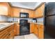 Fully equipped kitchen with wooden cabinetry, stone countertops, and modern appliances, including a built-in microwave at 16107 Dawnview Dr, Tampa, FL 33624