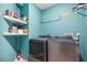 This laundry room offers modern gray appliances and ample shelving, perfect for keeping things organized at 16107 Dawnview Dr, Tampa, FL 33624