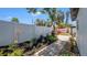 Landscaped backyard featuring a white fence, paved walkway, and a spa with a privacy screen at 1710 Shore Acres Ne Blvd, St Petersburg, FL 33703