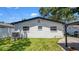 Home exterior featuring a green lawn and a backyard dining gazebo and spa at 1710 Shore Acres Ne Blvd, St Petersburg, FL 33703