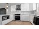 Contemporary kitchen with sleek appliances, white cabinetry, and stylish lighting fixtures at 1710 Shore Acres Ne Blvd, St Petersburg, FL 33703