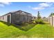 A cozy backyard with a screened-in patio, green lawn, and well-maintained landscaping at 17249 Star Banks St, Wimauma, FL 33598