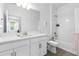 Well-lit bathroom with white cabinets and shower-tub combo with tiled walls at 17249 Star Banks St, Wimauma, FL 33598