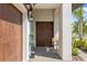 Inviting front entrance featuring a beautiful wood door, stylish lighting, and meticulous landscaping at 17249 Star Banks St, Wimauma, FL 33598