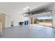Spacious garage with modern epoxy flooring, storage cabinets, and ample room for parking at 17249 Star Banks St, Wimauma, FL 33598
