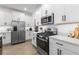 Modern kitchen with white cabinets, quartz countertops, and stainless steel appliances at 17249 Star Banks St, Wimauma, FL 33598