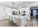 Bright, open kitchen with white cabinetry, a center island with seating, and stainless steel appliances at 17249 Star Banks St, Wimauma, FL 33598