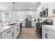 Modern kitchen with white cabinets, stainless steel appliances, and a large center island at 17249 Star Banks St, Wimauma, FL 33598