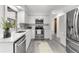 Open kitchen view with stainless steel appliances, white cabinets, and quartz countertops at 180 Rusk Cir, Spring Hill, FL 34606