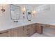 Bright bathroom with double sinks, stylish mirrors, sleek fixtures, and wood-grain vanity with a makeup counter at 1811 Bayou Grande Ne Blvd, St Petersburg, FL 33703