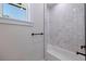 Modern bathroom with a shower and bath with white tile surround, matte black hardware, and window at 1811 Bayou Grande Ne Blvd, St Petersburg, FL 33703