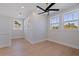 A light-filled bedroom featuring a modern ceiling fan and large windows overlooking lush palm trees at 1811 Bayou Grande Ne Blvd, St Petersburg, FL 33703