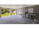 Spacious outdoor kitchen features a stainless steel grill, built-in cabinetry, a refrigerator, and views of backyard at 1811 Bayou Grande Ne Blvd, St Petersburg, FL 33703