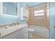 Cozy bathroom with a single vanity, bathtub, tiled walls, and neutral fixtures at 1819 Bayou Grande Ne Blvd, St Petersburg, FL 33703