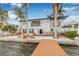 Beautiful waterfront home with a private dock, outdoor seating, and lush landscaping at 1819 Bayou Grande Ne Blvd, St Petersburg, FL 33703