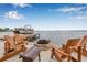 Outdoor patio with multiple chairs and a small table near the dock and fire pit at 1819 Bayou Grande Ne Blvd, St Petersburg, FL 33703