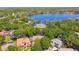 Stunning aerial view of homes nestled among lush trees near a beautiful blue lake at 1940 Floresta View Dr, Tampa, FL 33618