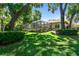 Beautiful backyard with a screened-in pool area, mature trees, and well-maintained lawn at 1940 Floresta View Dr, Tampa, FL 33618