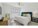 Cozy bedroom featuring a plush bed with a blue headboard, natural light, and stylish furnishings at 1940 Floresta View Dr, Tampa, FL 33618