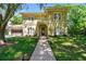Inviting exterior elevation showcasing manicured lawn and elegant architectural details on a sunny day at 1940 Floresta View Dr, Tampa, FL 33618