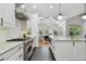 Modern kitchen featuring white cabinetry, stainless steel appliances, and a view into the dining area at 1940 Floresta View Dr, Tampa, FL 33618