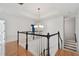 Bright open landing with staircase features hardwood floors, black and white railings and a modern chandelier at 1940 Floresta View Dr, Tampa, FL 33618