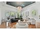 Sophisticated living room featuring a chic chandelier, plush seating, and floor-to-ceiling windows at 1940 Floresta View Dr, Tampa, FL 33618
