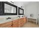 The main bathroom has double vanities, decorative mirrors, vanity space, neutral tile and warm wood cabinets at 1940 Floresta View Dr, Tampa, FL 33618
