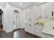 A bright pantry with white cabinetry, granite counters, and exterior door access at 1940 Floresta View Dr, Tampa, FL 33618