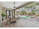 Patio area with dining table and chairs overlooking an inviting screened-in pool at 1940 Floresta View Dr, Tampa, FL 33618