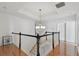 Bright foyer landing showcases hardwood floors, a modern chandelier, and white railings with black trim at 1940 Floresta View Dr, Tampa, FL 33618
