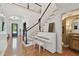 Elegant staircase with hardwood steps, black railings, and a charming white piano in the foyer at 1940 Floresta View Dr, Tampa, FL 33618
