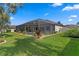 Inviting backyard features a screened lanai with a pool, lush landscaping, and well-maintained lawn at 19830 Strathmore Pl, Land O Lakes, FL 34638