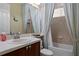Bathroom with a vanity, faucet, and shower-tub combo with light blue curtains at 19830 Strathmore Pl, Land O Lakes, FL 34638