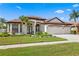 Stunning single-story home with a three-car garage, well-manicured lawn, and lush tropical landscaping at 19830 Strathmore Pl, Land O Lakes, FL 34638