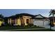 Beautifully landscaped one-story home with manicured lawn, a two-car garage, and warm exterior lighting at 19830 Strathmore Pl, Land O Lakes, FL 34638
