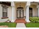 Inviting front entrance with double doors, white columns, and well-manicured landscaping at 19830 Strathmore Pl, Land O Lakes, FL 34638
