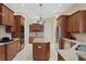 Spacious kitchen featuring wood cabinets, an island, granite counters, tile floors and stainless steel appliances at 19830 Strathmore Pl, Land O Lakes, FL 34638