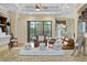 Open living room featuring hardwood floors, tray ceilings, and a view of the pool at 19830 Strathmore Pl, Land O Lakes, FL 34638