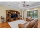 Comfortable living room featuring hardwood floors, a ceiling fan, and a view of the pool at 19830 Strathmore Pl, Land O Lakes, FL 34638