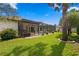 A covered patio with a screened-in in-ground pool overlooks a meticulously maintained lawn and garden at 19830 Strathmore Pl, Land O Lakes, FL 34638