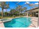 Screened-in pool and hot tub with sunny backyard and patio seating area, perfect for outdoor relaxation at 19830 Strathmore Pl, Land O Lakes, FL 34638