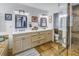 Lavish Primary bathroom showcasing a double sink vanity, framed mirrors, stone floors, and a glass enclosed shower at 1990 59Th N St, St Petersburg, FL 33710